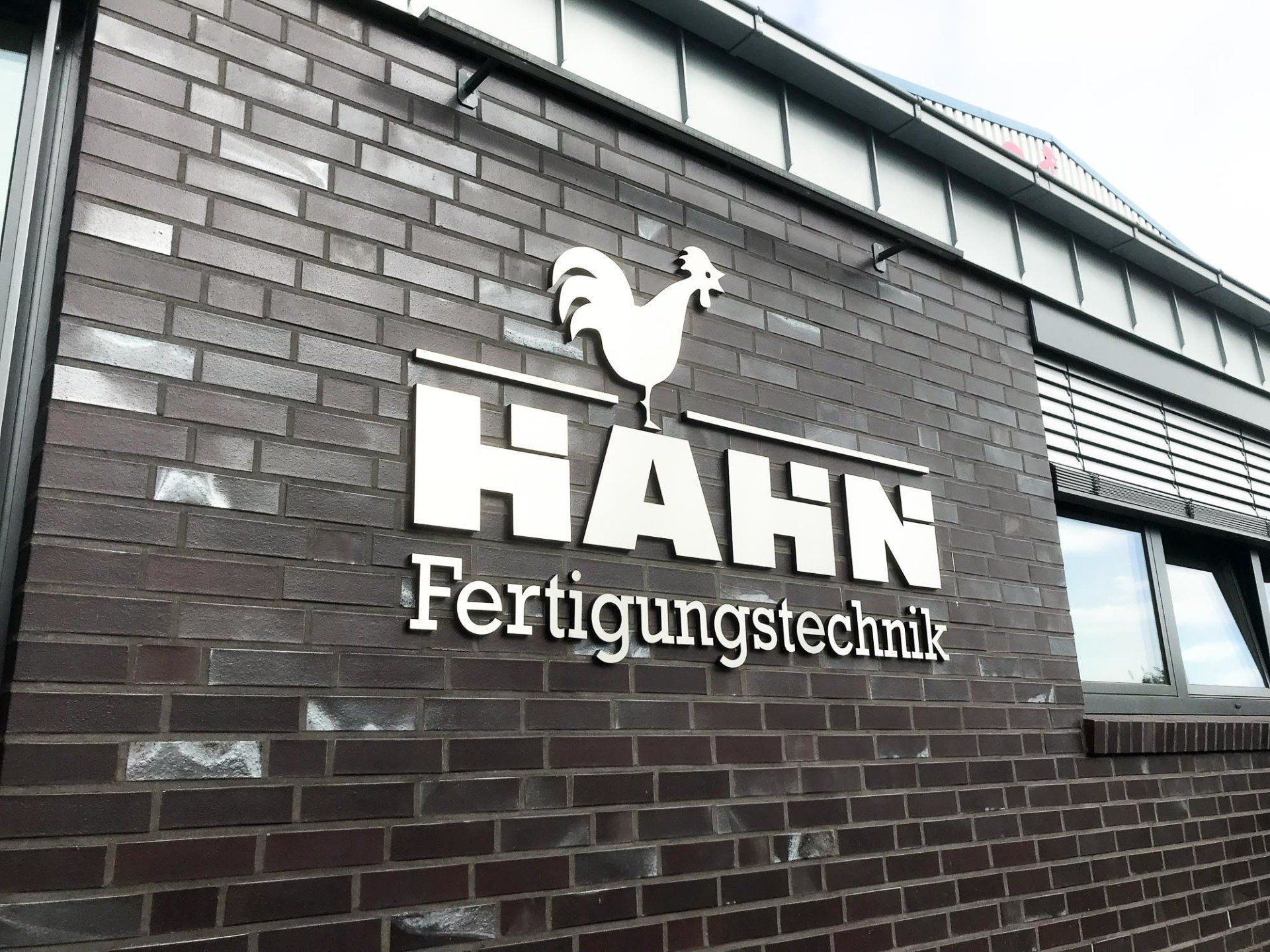 Ein Backsteingebäude mit einem Schild mit der Aufschrift „hahn fertigungstechnik“