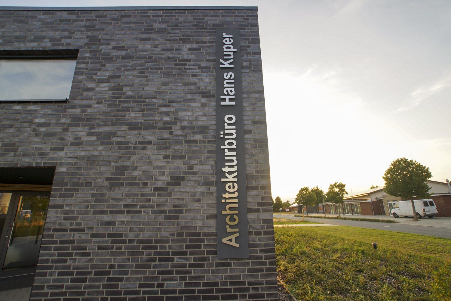 Ein Backsteingebäude mit einem Schild mit der Aufschrift „Architektbüro Hans Kuper“