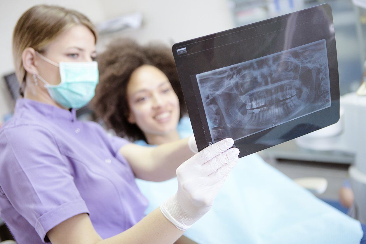 dentist and patient looking at oral xrays