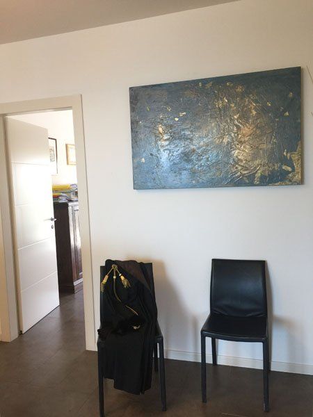 sala di attesa con toga sulla sedia e quadro appeso in uno studio legale