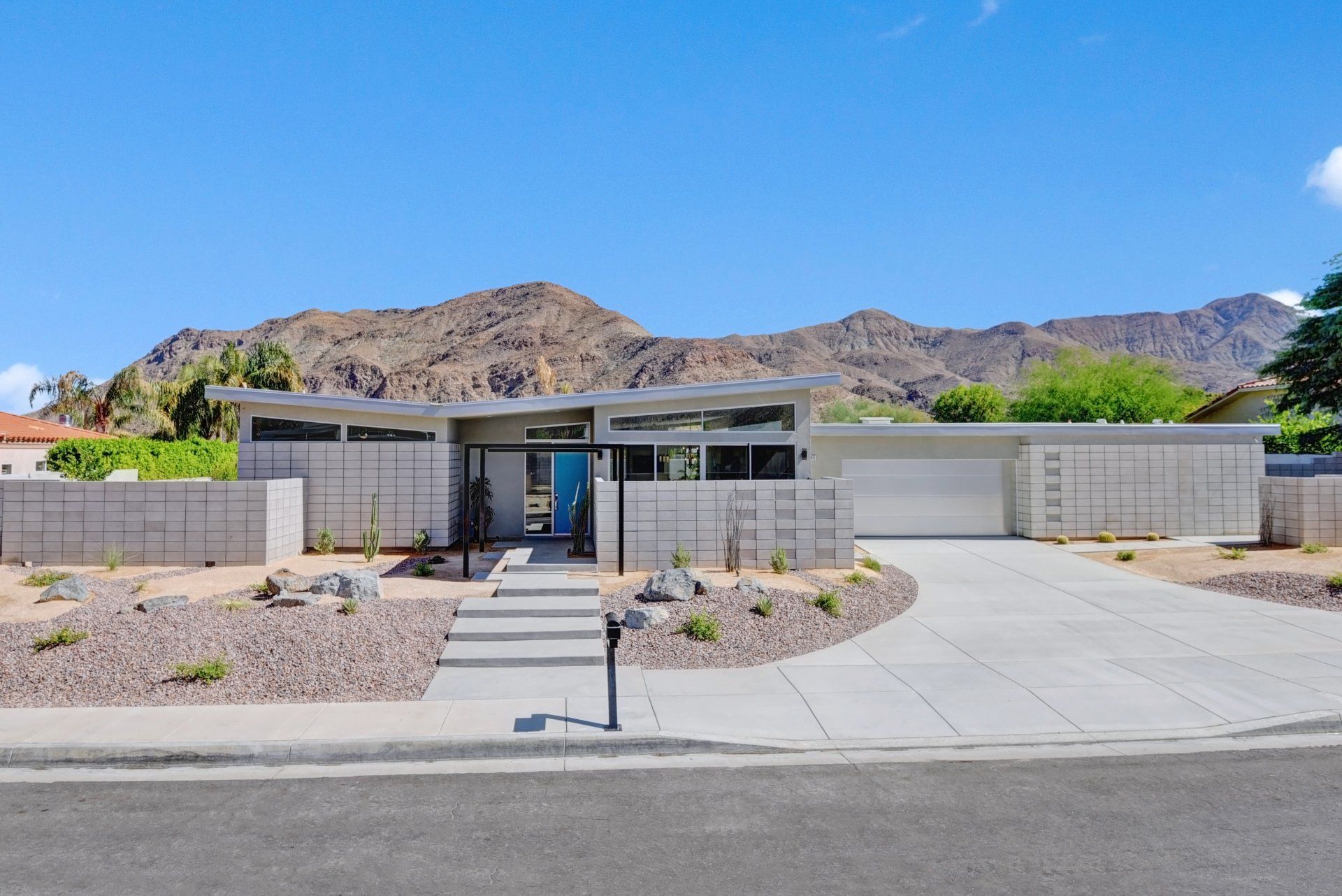 A modern house with mountains in the background is for sale