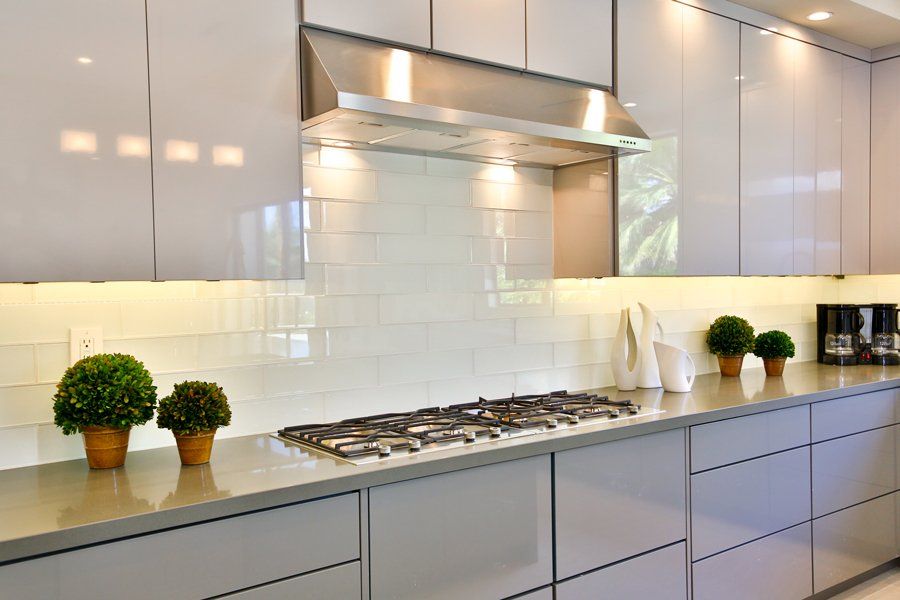 A kitchen with white cabinets and a stove top oven