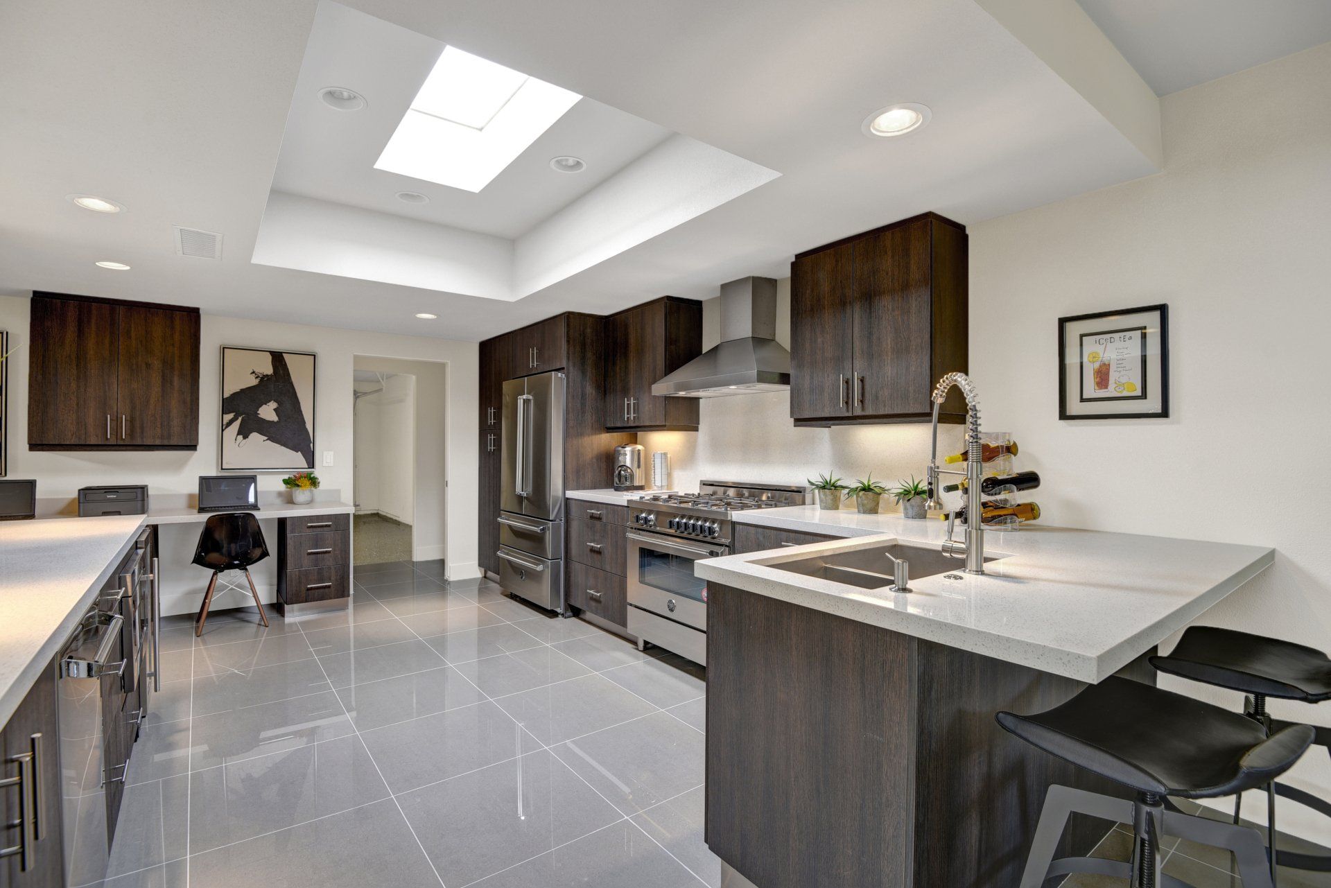 A kitchen with stainless steel appliances and a skylight.