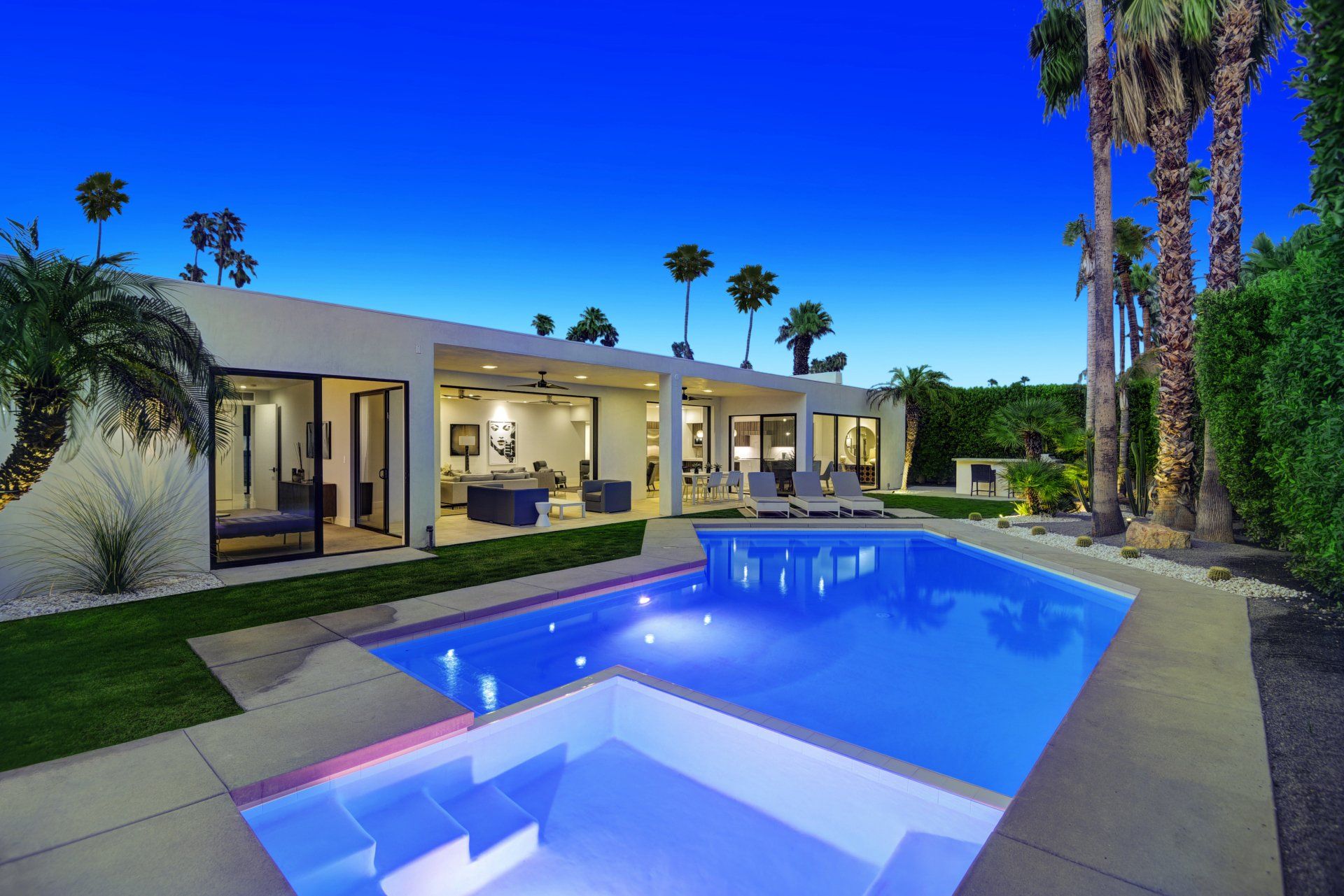 A large swimming pool is in the backyard of a house.