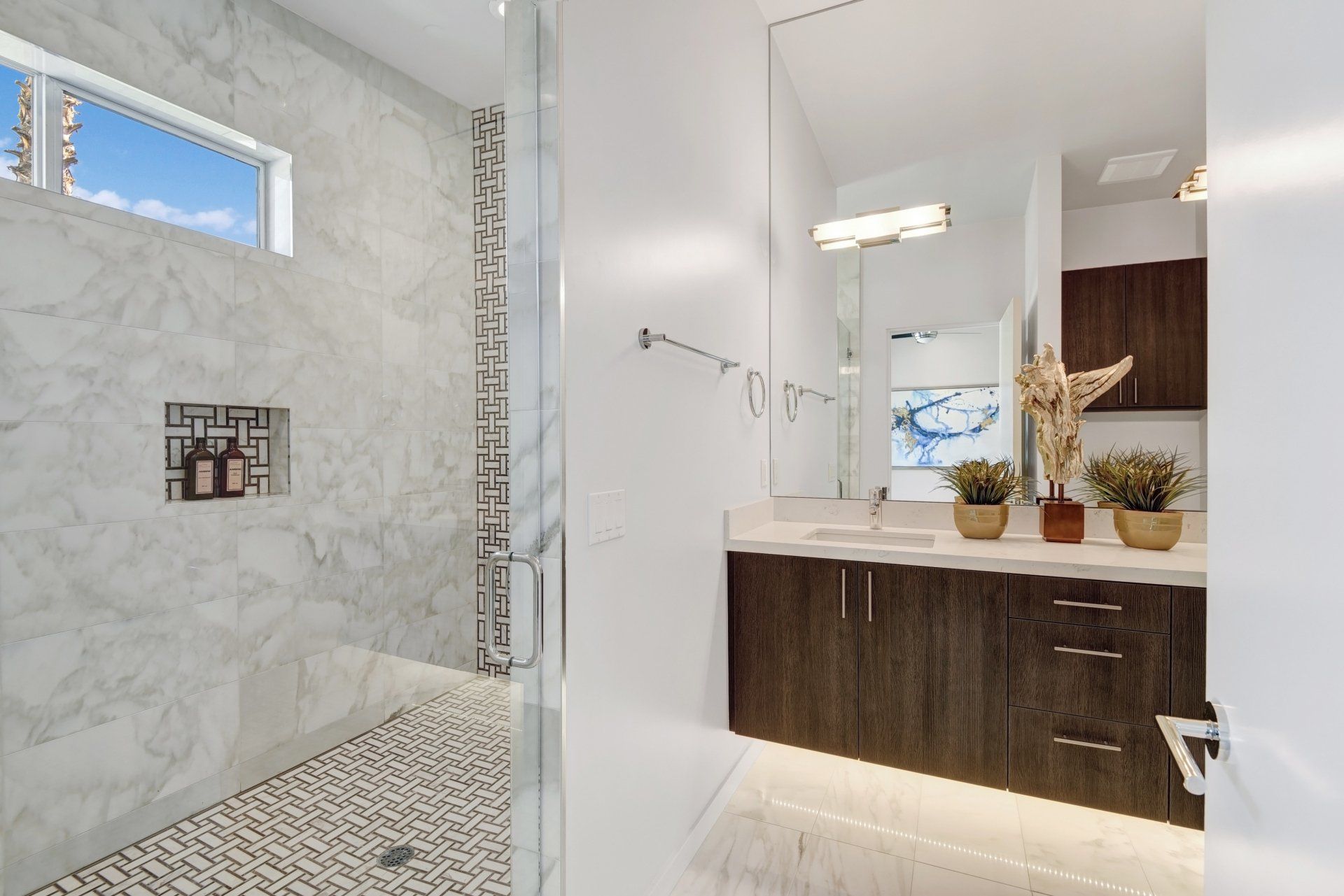 A bathroom with two sinks and a walk in shower