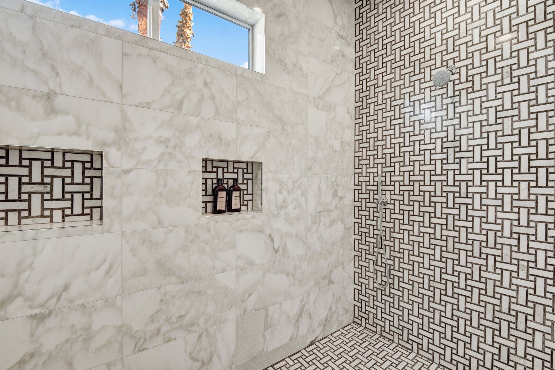 A bathroom with a walk in shower and a window.