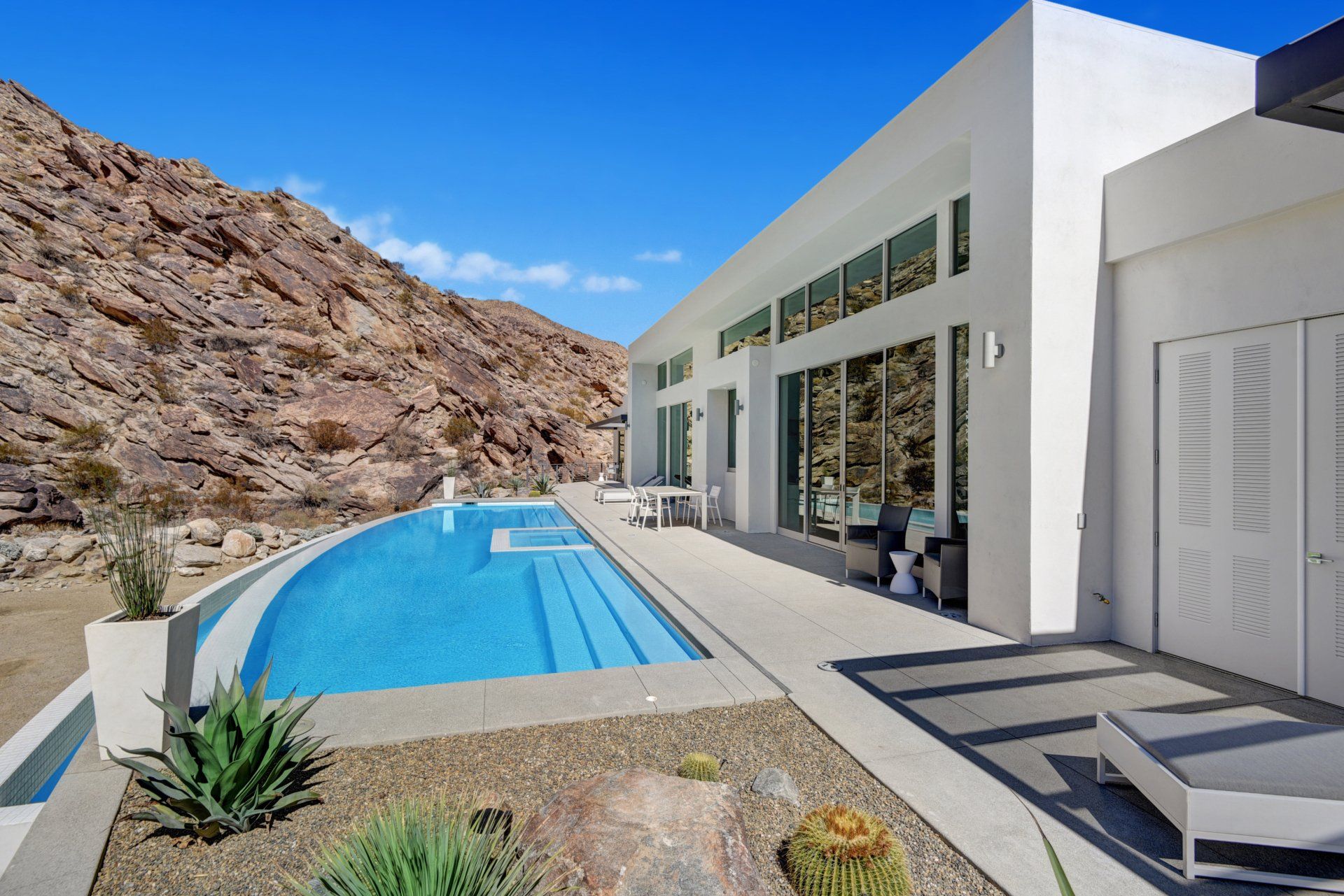 A large white house with a large swimming pool in front of it