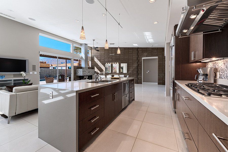A kitchen with a large island in the middle and a stove top oven.