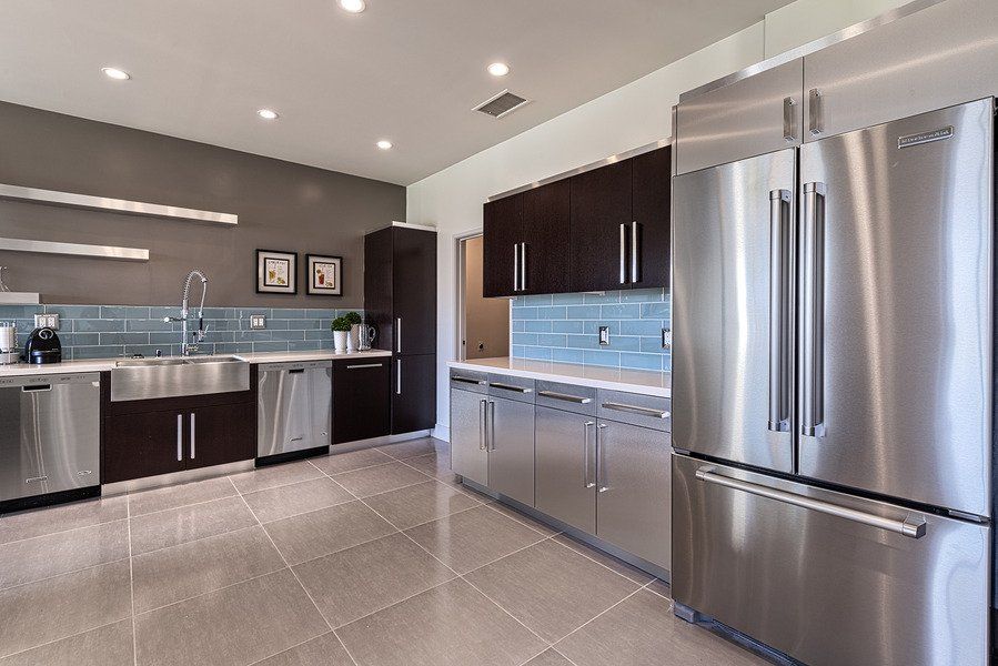 A kitchen with stainless steel appliances and a stainless steel refrigerator.