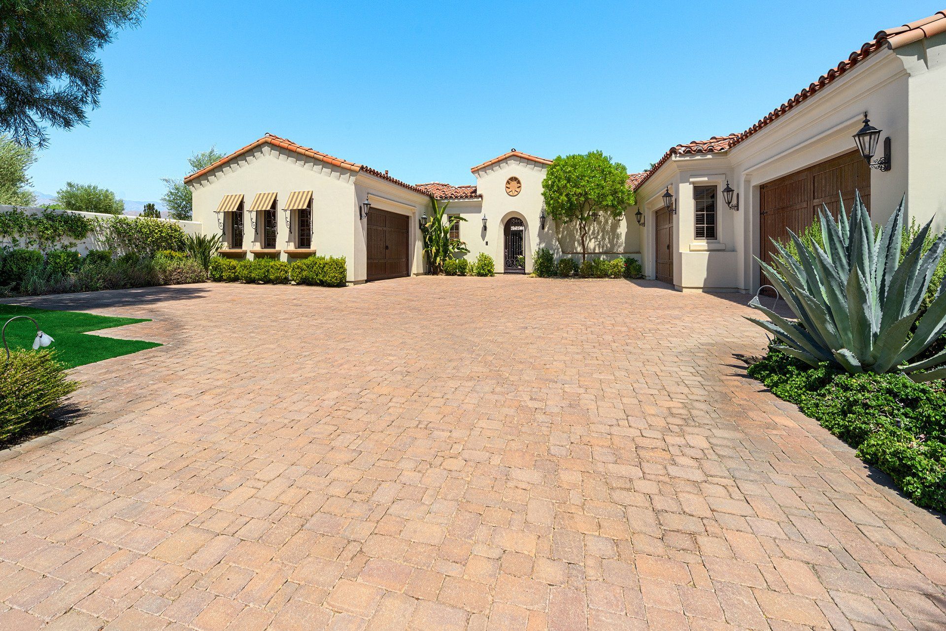 A large house with a brick driveway leading to it