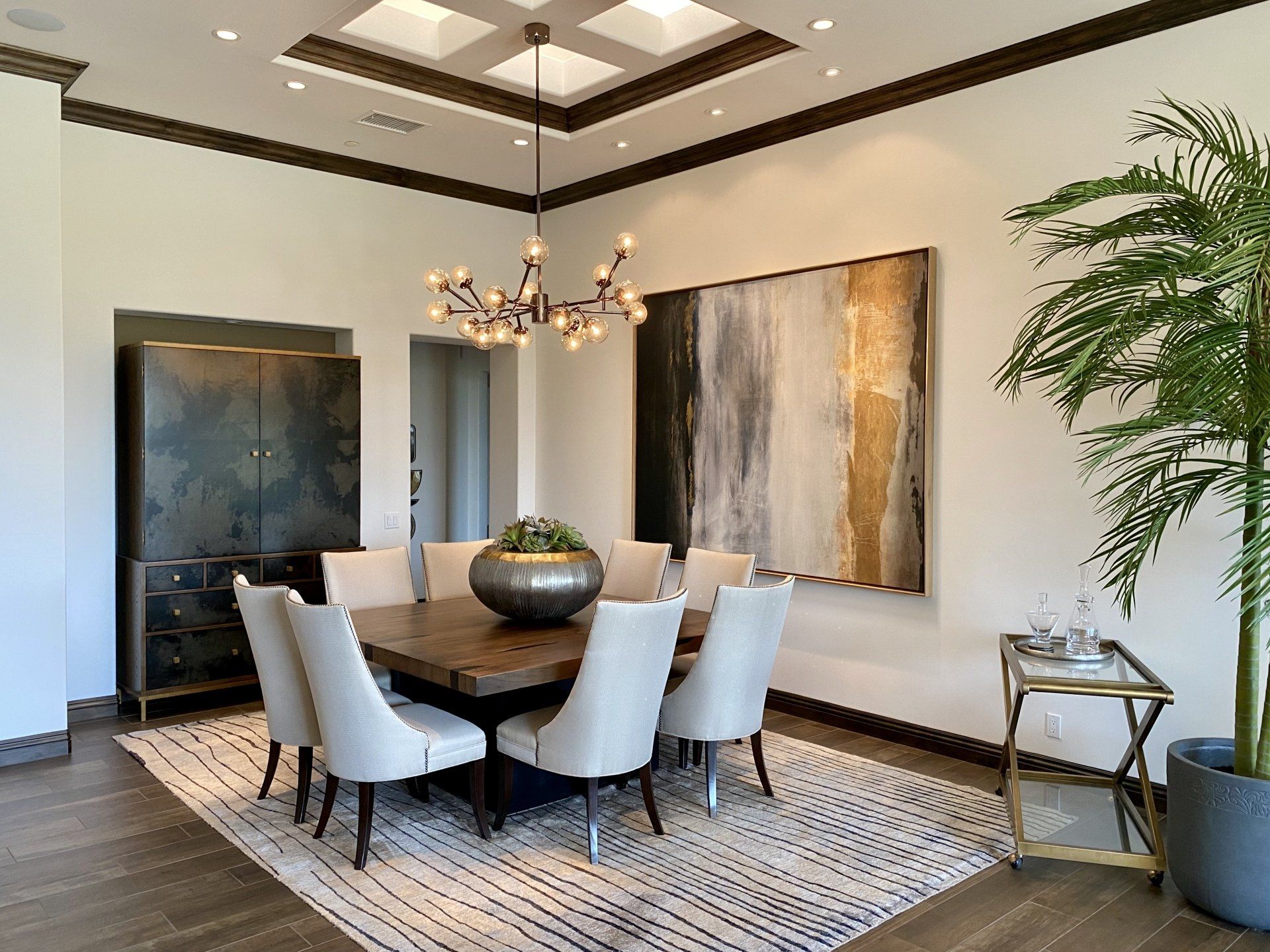 A dining room with a table and chairs and a chandelier hanging from the ceiling.