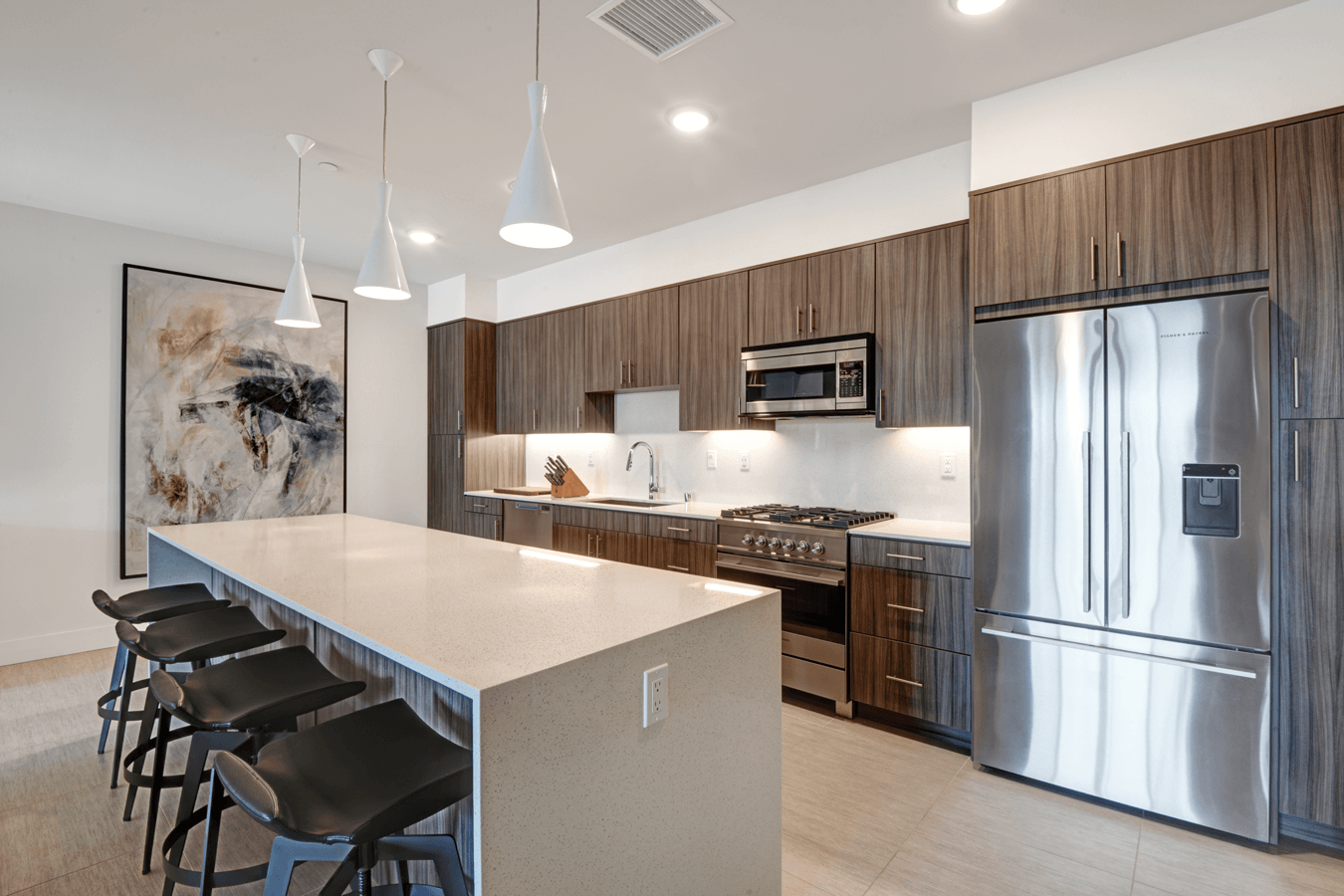 A kitchen with stainless steel appliances and a large island.