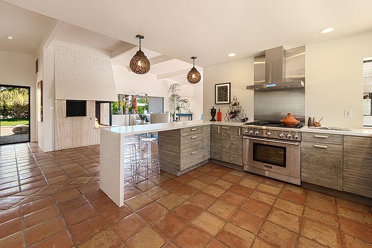 A kitchen with stainless steel appliances and a tiled floor.