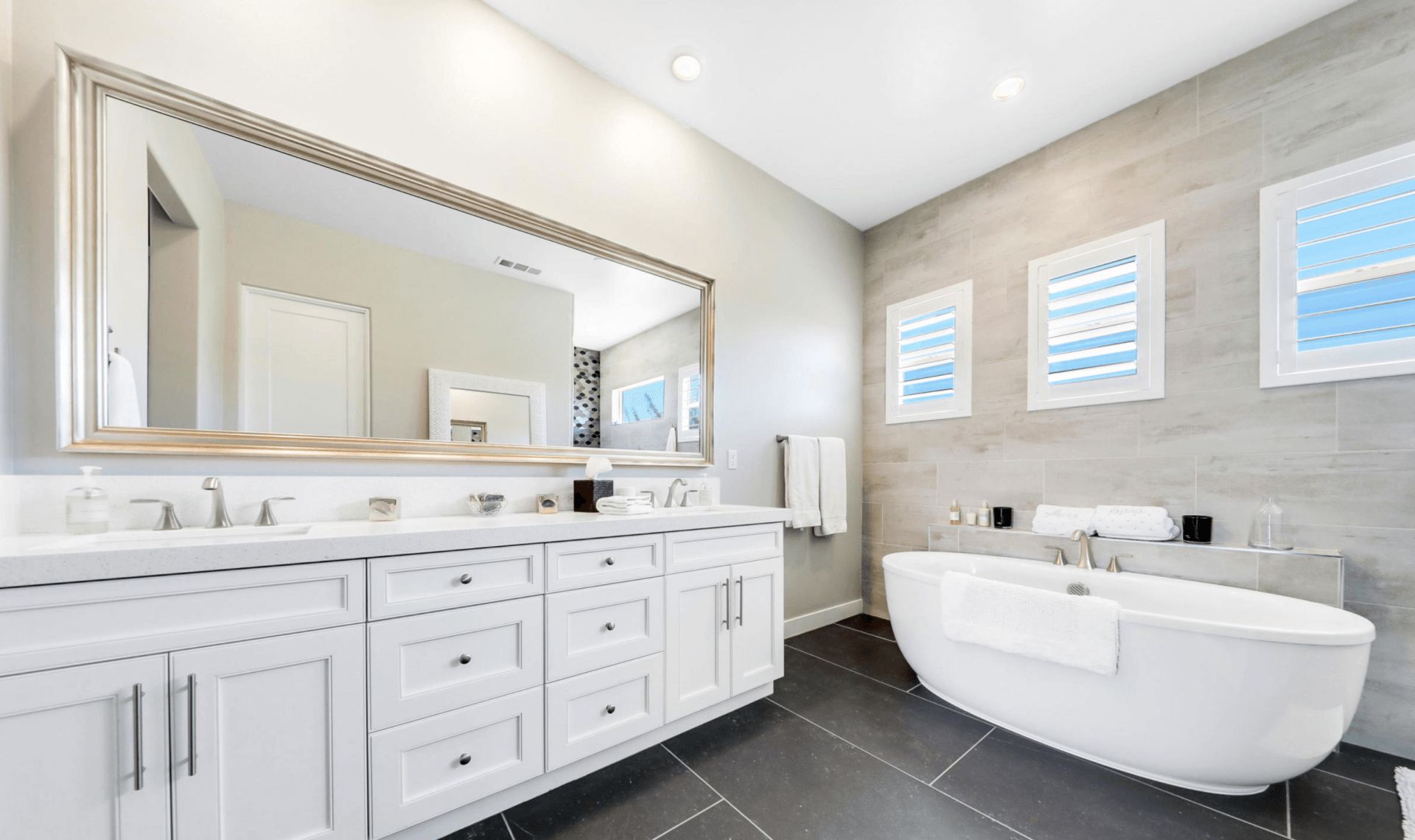 A bathroom with two sinks , a large mirror and a bathtub.