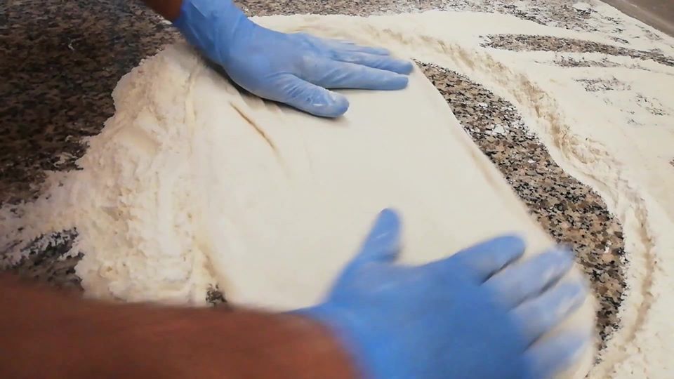 pizzaiolo che stende impasto