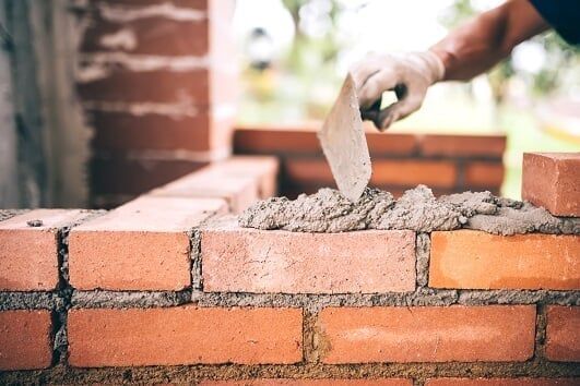 Concrete — Worker Building Walls with Brick Mortar in Philadelphia, PA