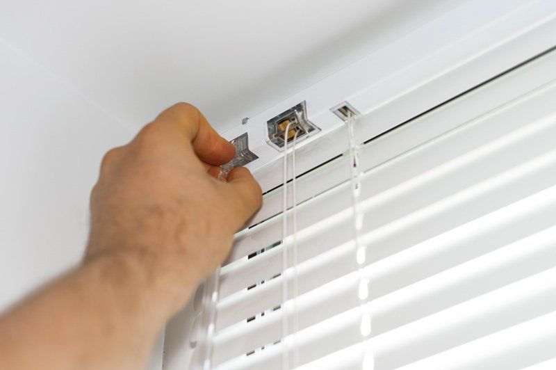 Worker Installing White Blinds — Denham Springs, LA — Blinds By Tones & Textures Worker Installing White Blinds — Denham Springs, LA — Blinds By Tones & Textures