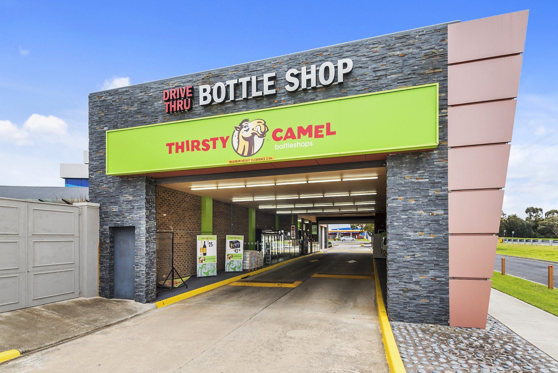Thirsty Camel bottle shop with a drive-through. Exterior view with green and brown signage.