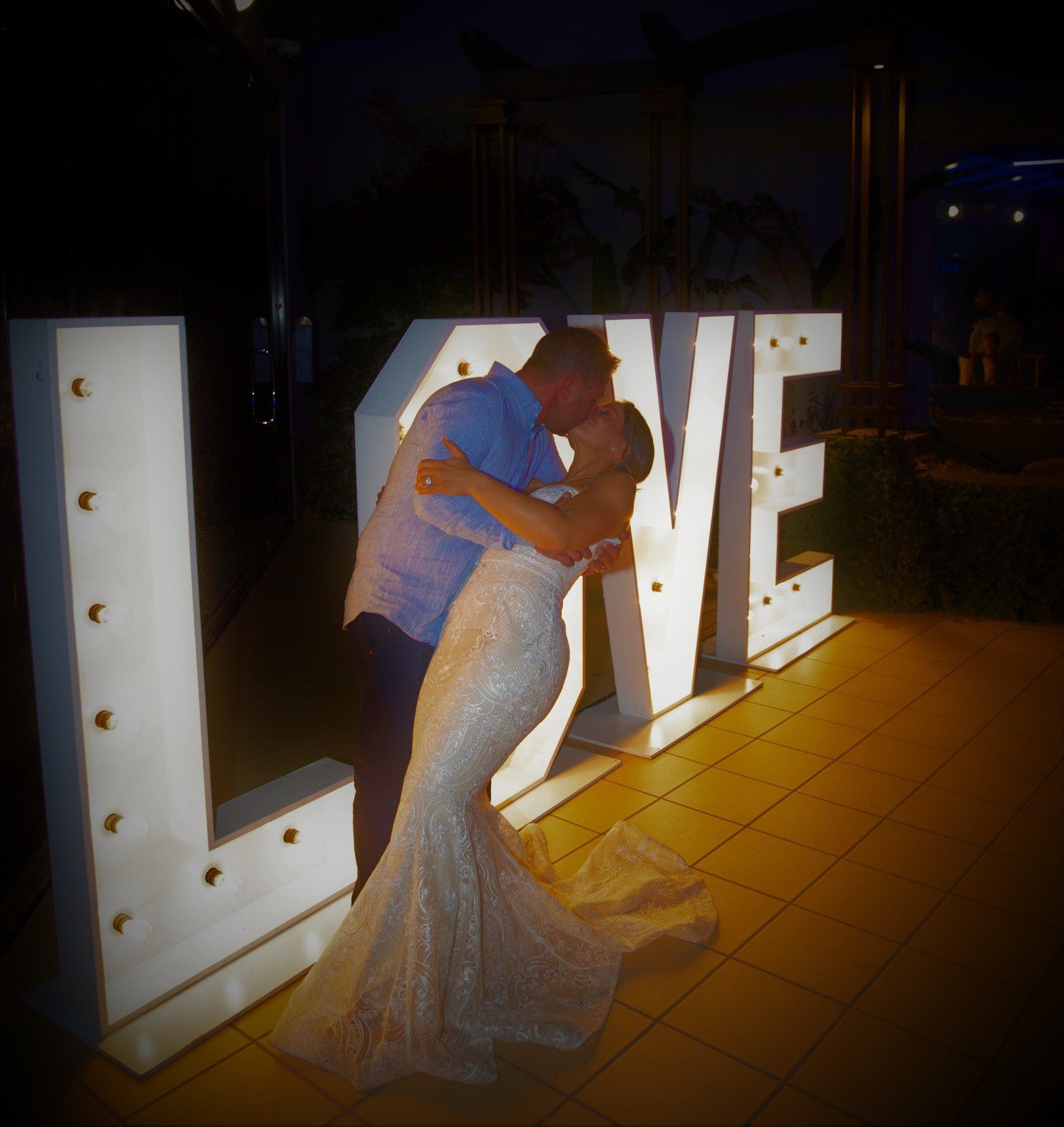 Couple embracing, kissing in front of large 
