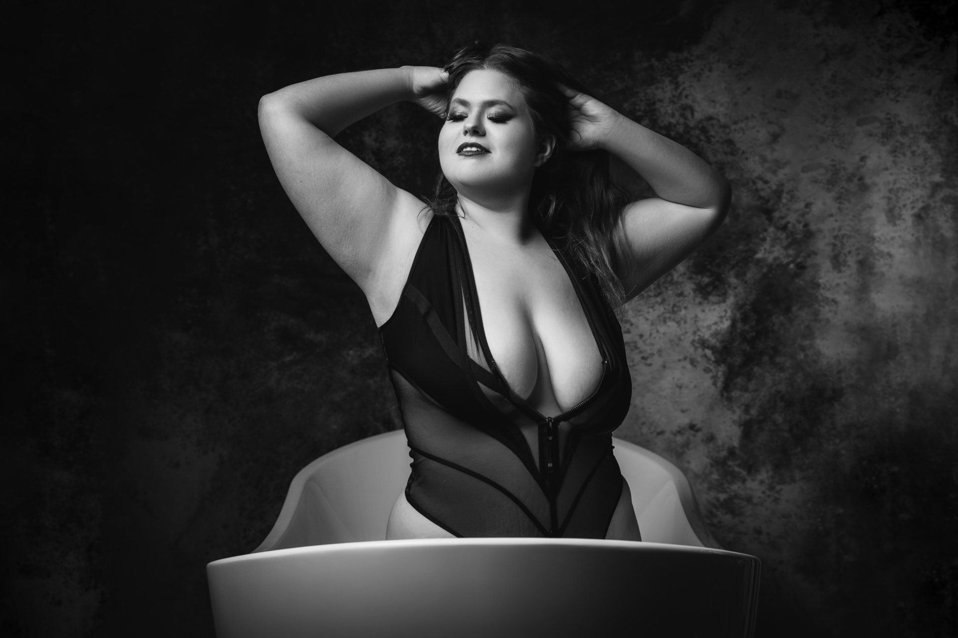 boudoir image of woman kneeling in bathtub
