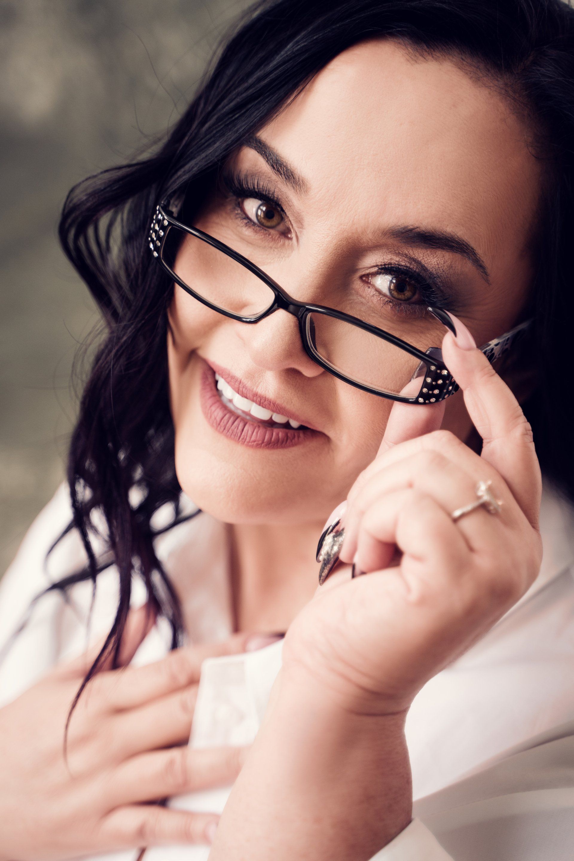 A woman wearing glasses and a white shirt.