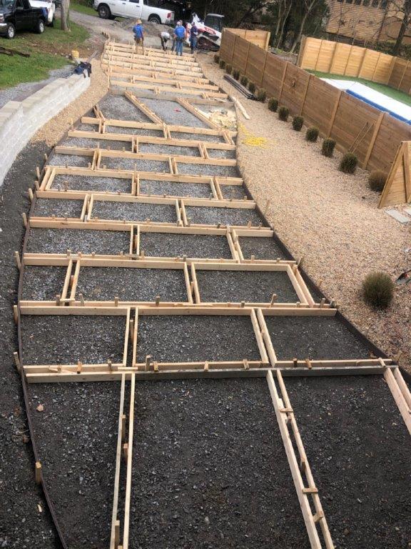 Wooden framing laid over a gravel walkway under construction in a residential yard