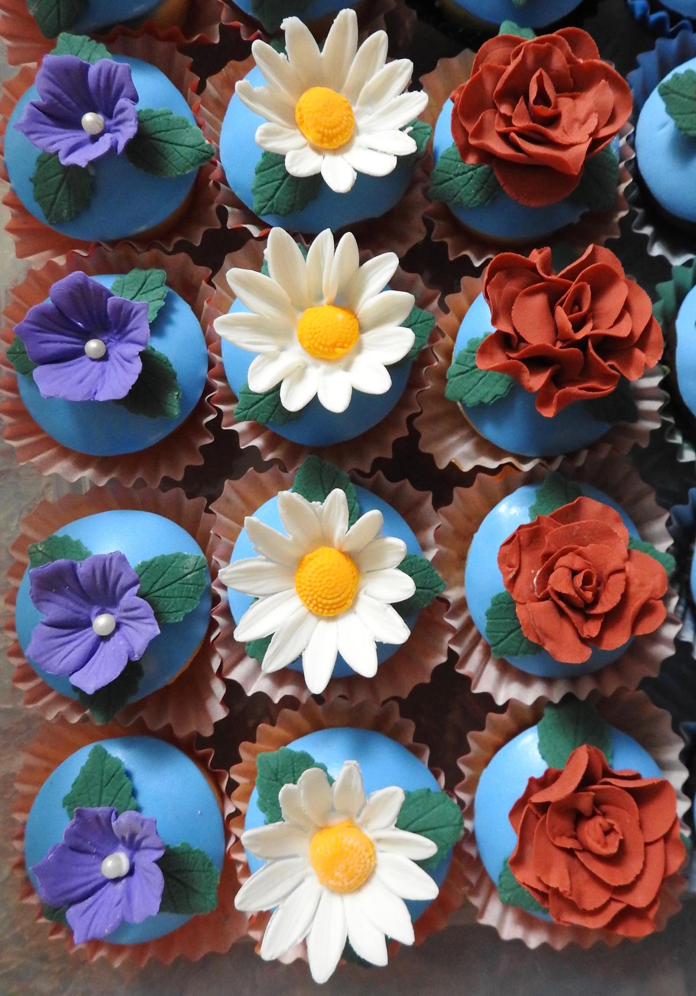 Cupcakes with sugar flowers dasies and roses.
