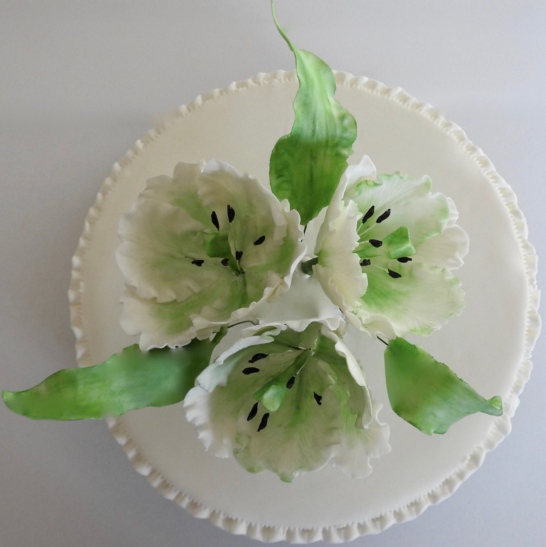 Single tiered birthday cake with white and green sugar tulips.