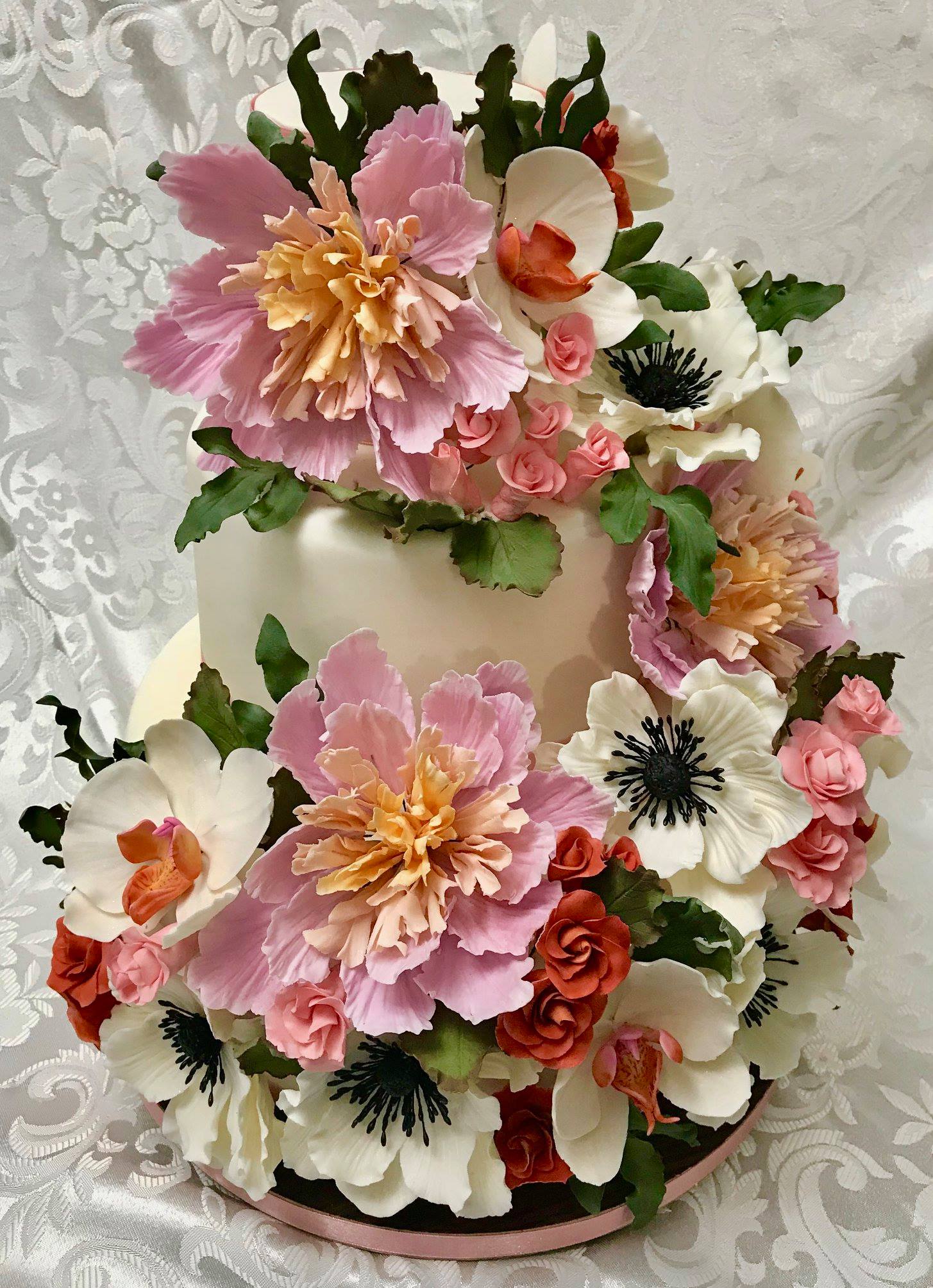 3 tiered Wedding Cake with cascade of sugar roses, sugar orchids and sugar anemones