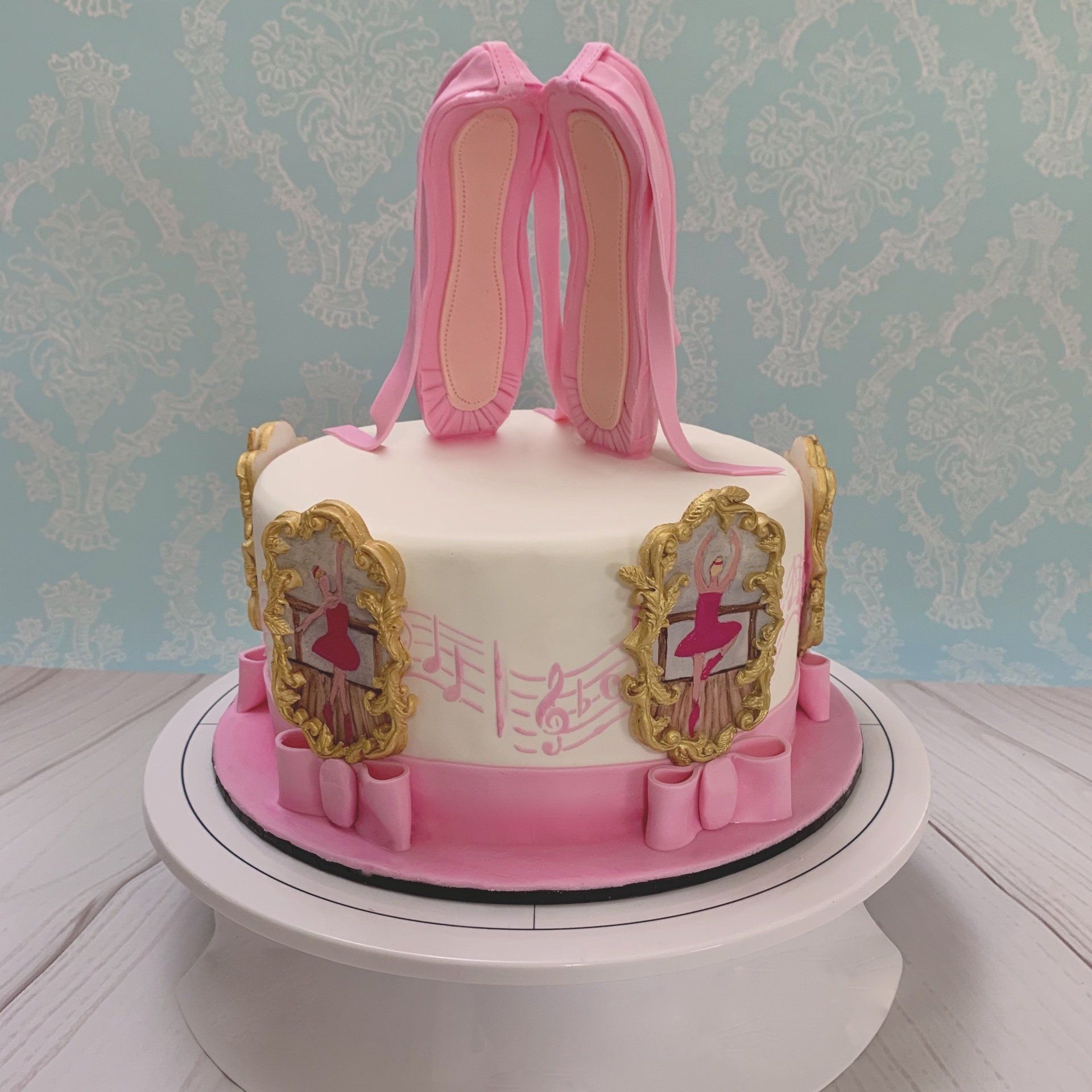 Girls Ballet Themed Cake. With Hand sculpted 3d Fondant Ballet Slippers on top, and hand painted ballerinas around the sides of the cake. Back