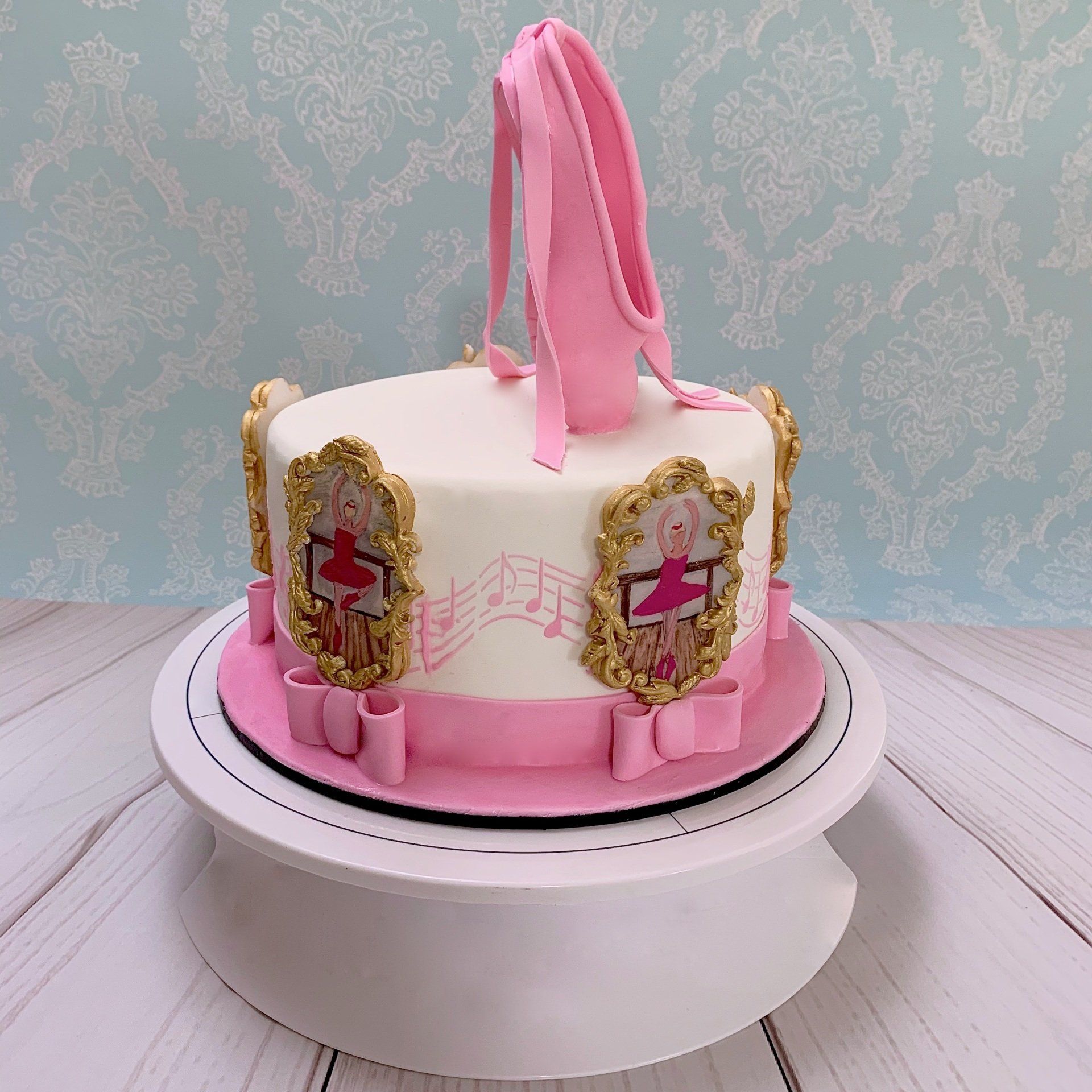 Girls Ballet Themed Cake. With Hand sculpted 3d Fondant Ballet Slippers on top, and hand painted ballerinas around the sides of the cake. Side 2