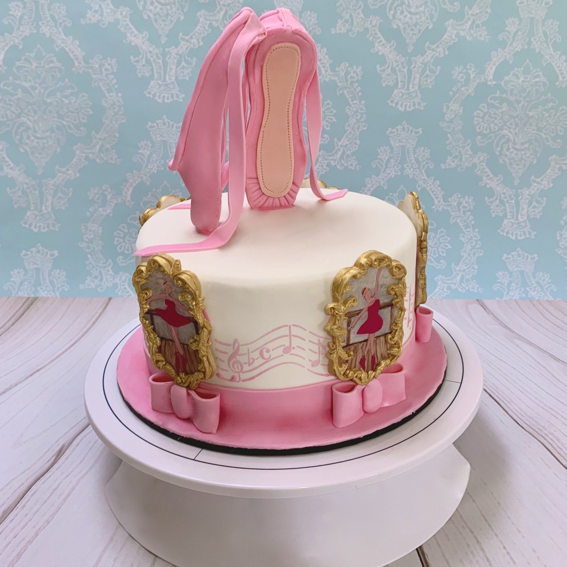Girls Ballet Themed Cake. With Hand sculpted 3d Fondant Ballet Slippers on top, and hand painted ballerinas around the sides of the cake. side 1