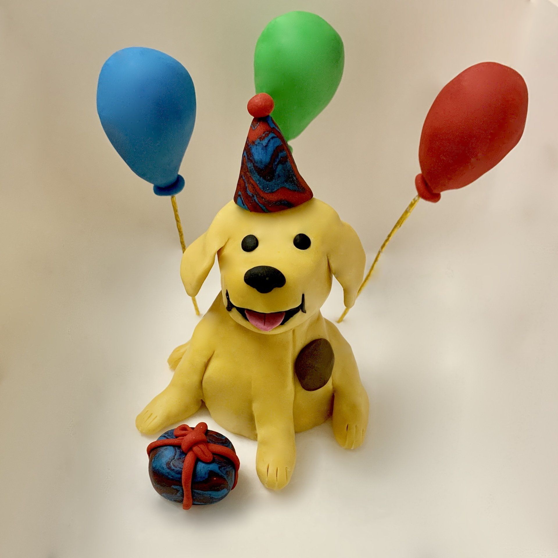Kids cake topper - Hand sculpted fondant dog with fondant balloons.