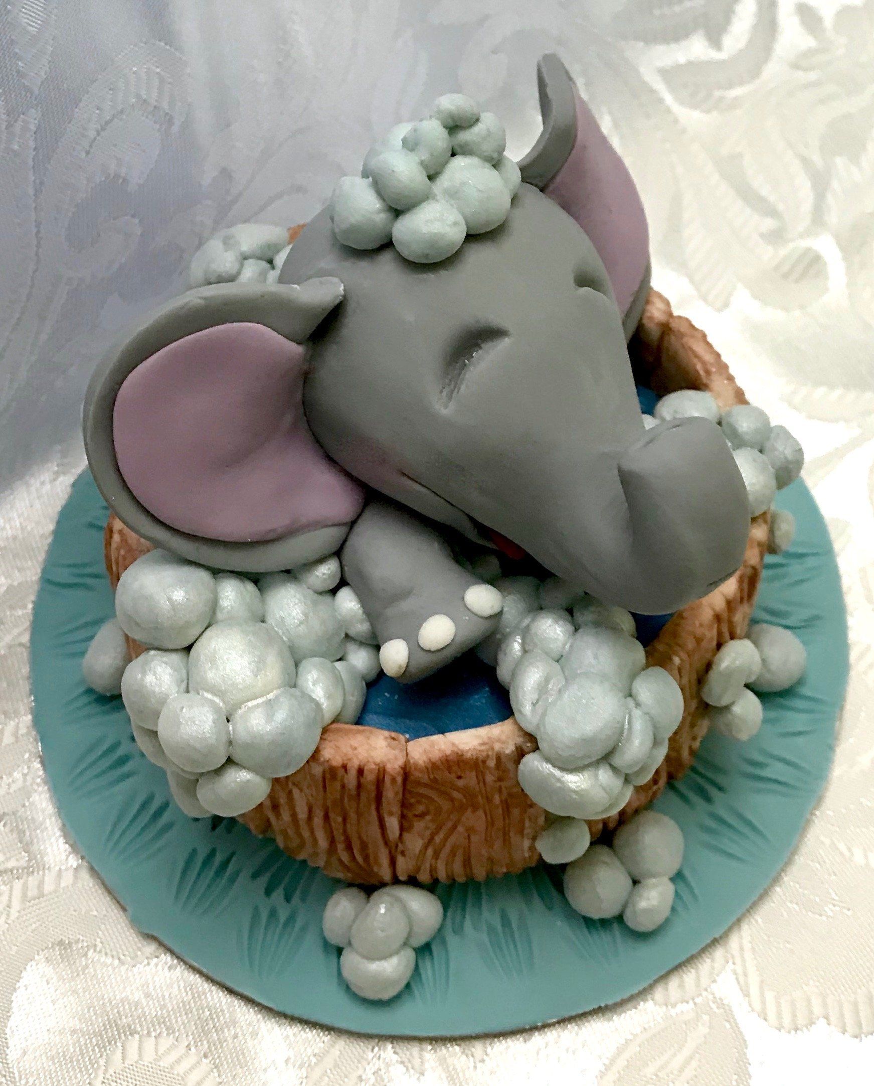 Cute Elephant splashing in a tub cake topper.