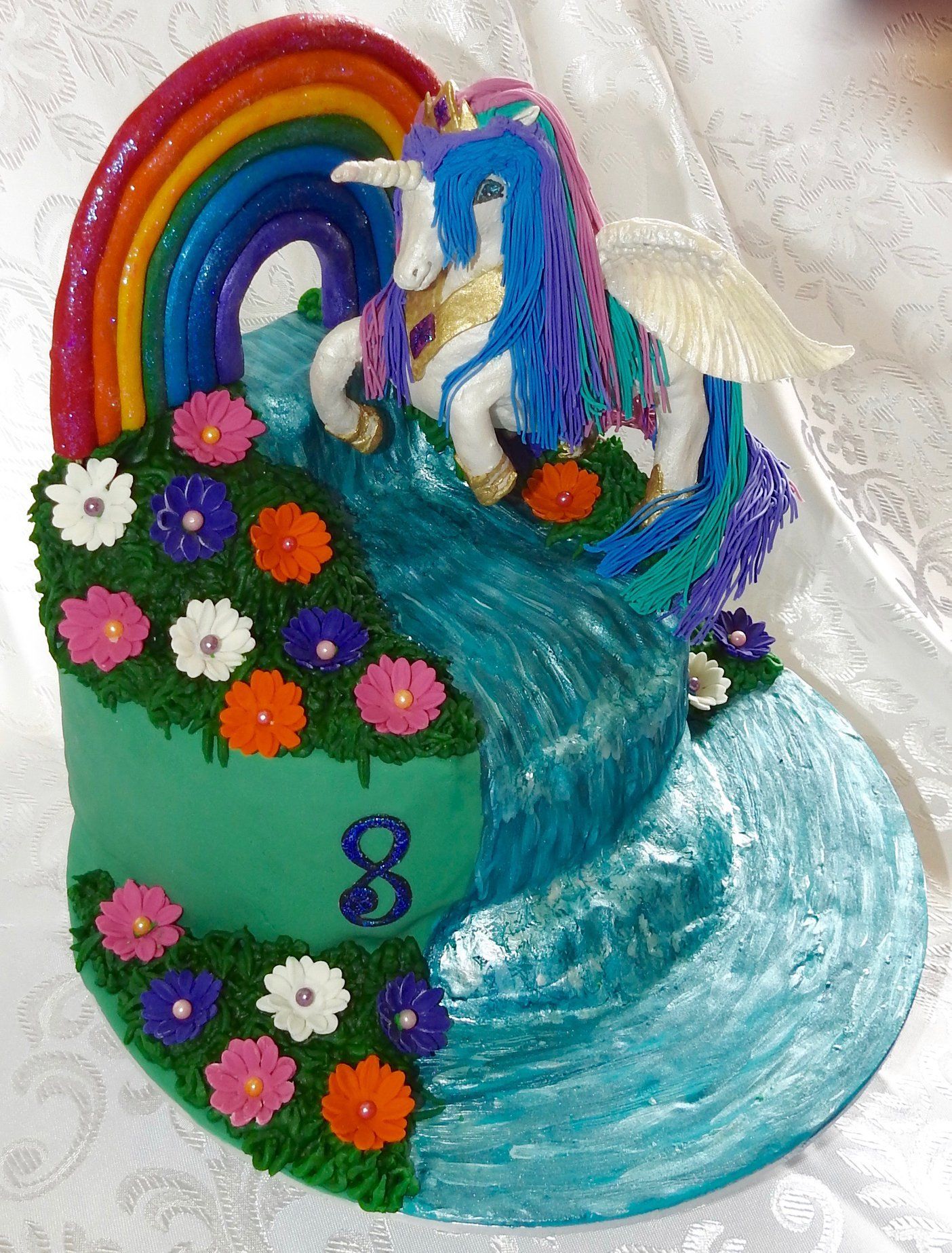 Girls 8th Birthday cake. Unicorn pony, Rainbow, waterfall and flowers.
