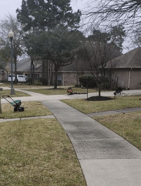 Lawn treatment service in Conroe with equipment on yard