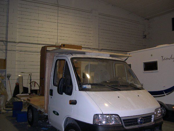 Camion a pianale bianco parcheggiato all'interno di un garage o di un magazzino.