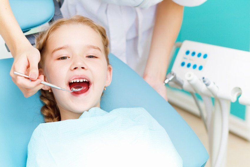A young girl receives dental treatment