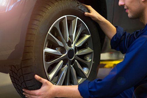 mechanic removing wheel from car