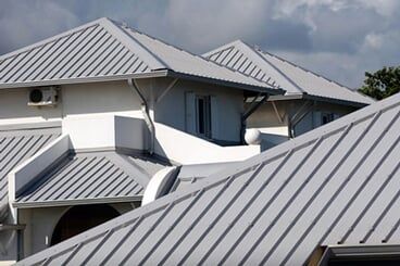 A building with a grey standing seam metal roof