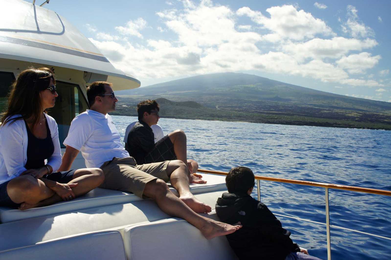 A group of people are sitting on a boat in the ocean.