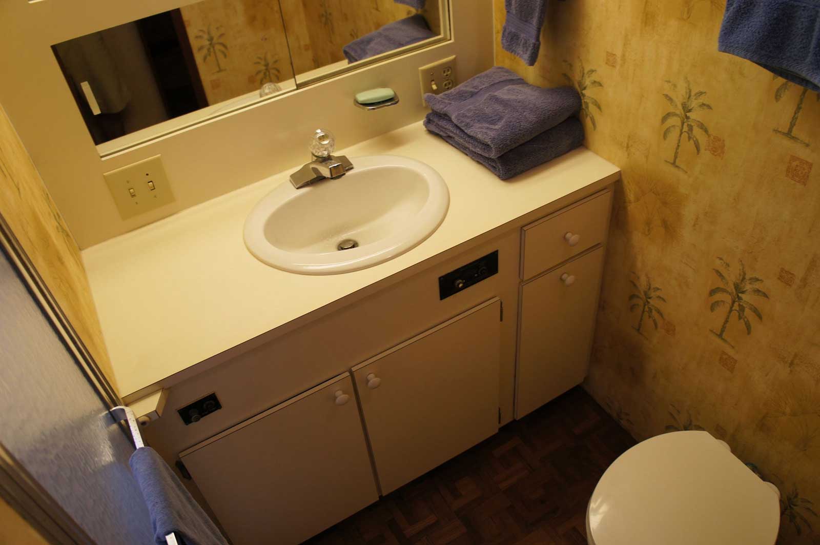 A bathroom with a toilet a sink and a mirror