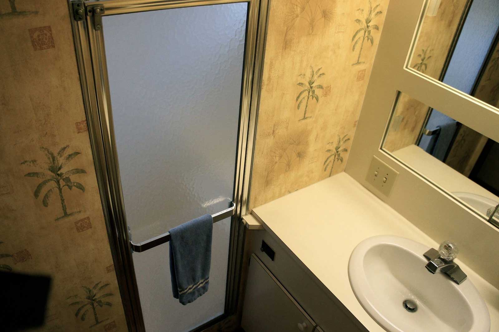 A bathroom with a sink a refrigerator and a mirror
