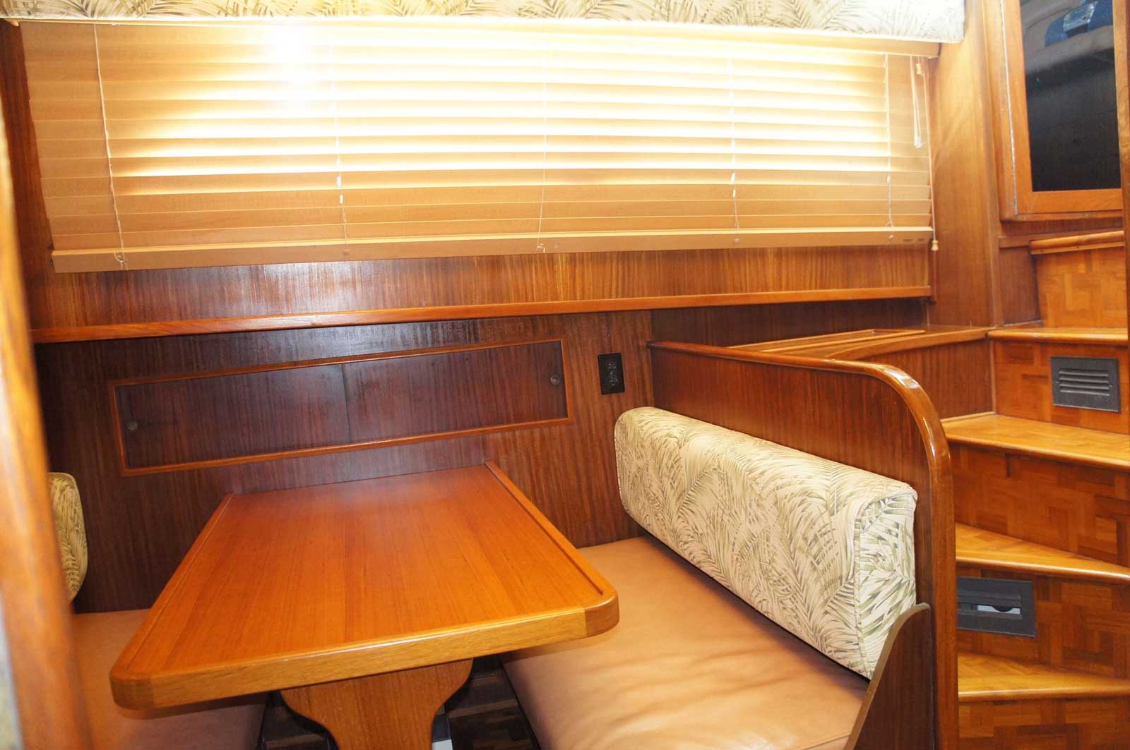 A wooden table and bench in a room on a boat.