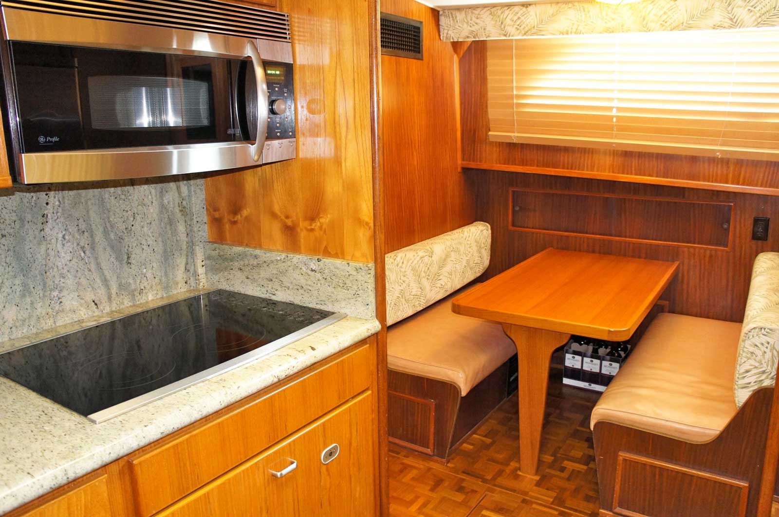 A kitchen with a table and benches and a microwave