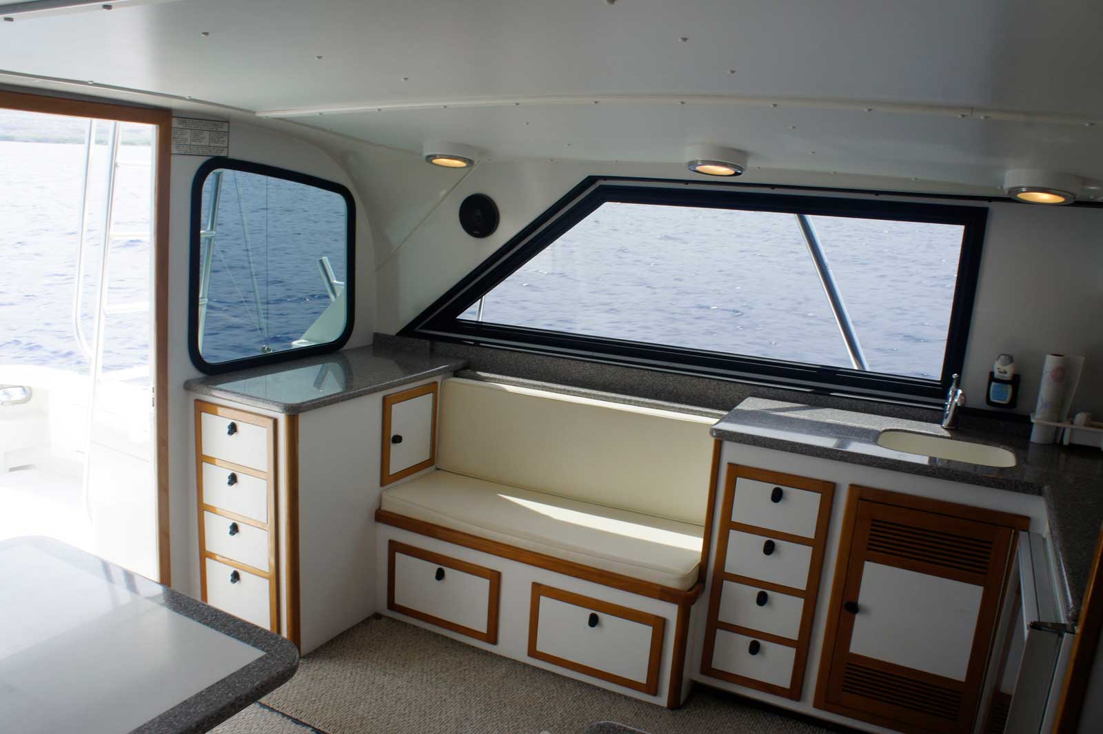 The inside of a boat with a bench and drawers.