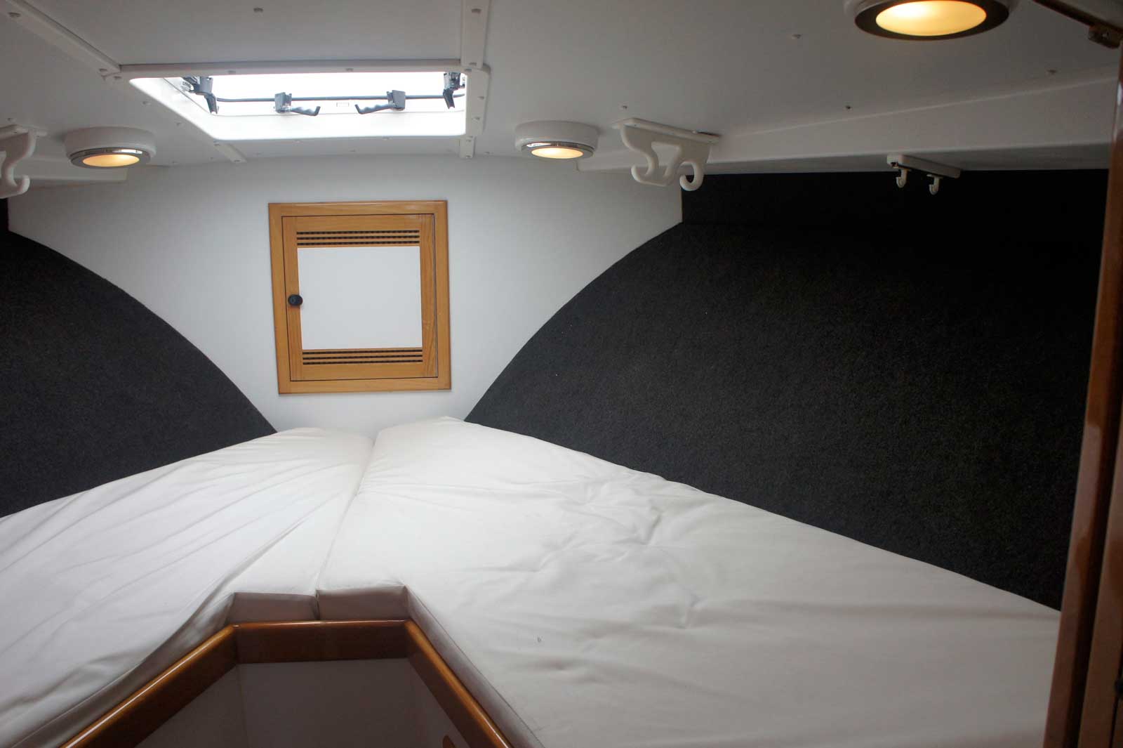 The inside of a boat with a bed and a window