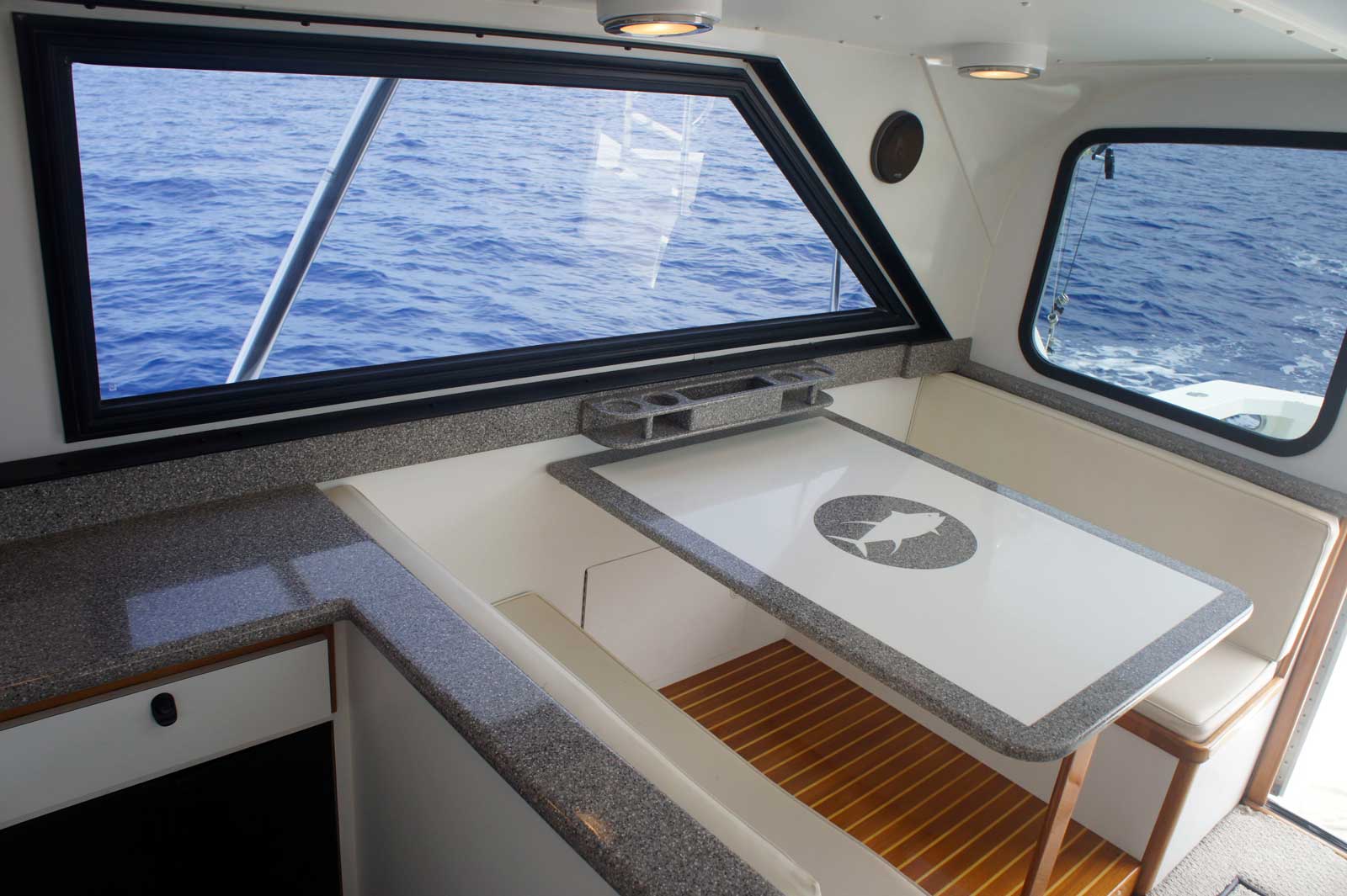 A boat with a table and a window overlooking the ocean.