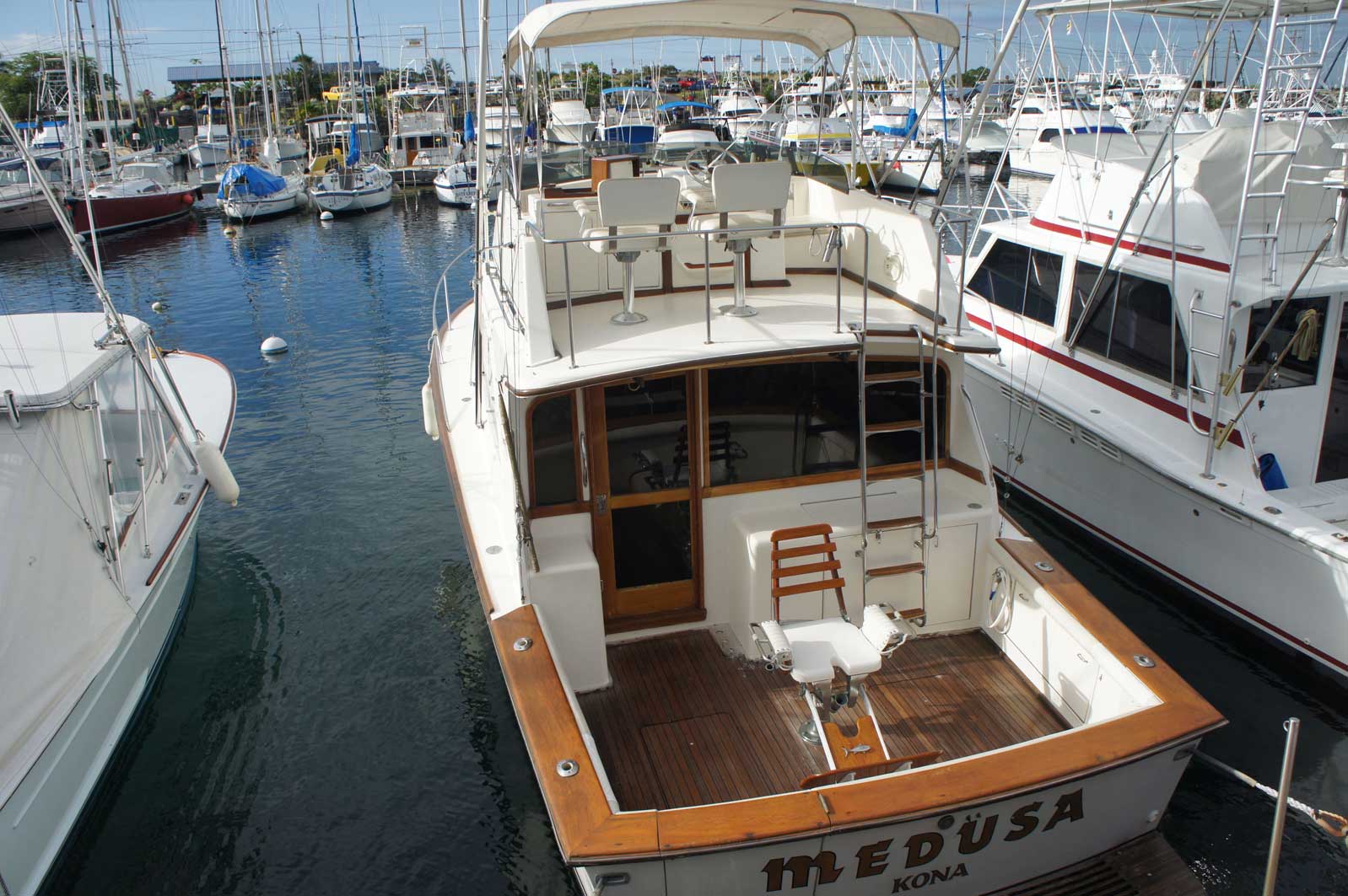 A boat named medusa is docked in a marina