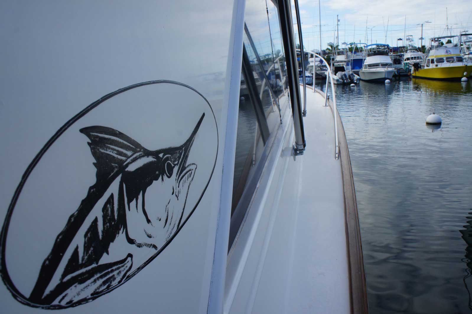The side of a boat has a picture of a marlin on it
